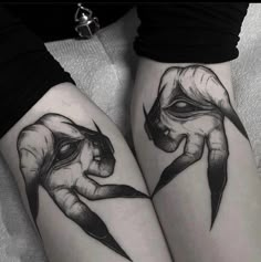 two women with tattoos on their legs holding scissors