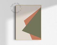 a white wall with a green, orange and beige geometric design hanging on it's side