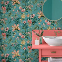 a sink and mirror in a room with floral wallpaper