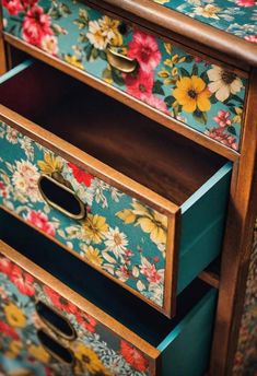 an old dresser with flowers painted on the drawers and brass pulls in front of it