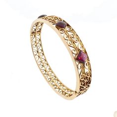 "A very nice late Victorian hinged bangle bracelet worked in a pierced scrolling design. The front features a row of three square cabochon rhodolite garnets set diagonally. The rhodolites have a lovely purplish hue that distinguishes them from their more common all reddish-brown garnet cousins. The bangle is fairly wide, but the piercing gives it an elegant lightness. The clasp is marked \"14K.\" * Origin: America, ca. 1900 * Condition: excellent * Dimensions: 7/16\" wide; inner circumference, 7 Love Token, Gold Engraving, Rhodolite Garnet, Reddish Brown, Hinged Bangle, 3 Carat, Bangle Bracelet, Gold Diamond, Garnet