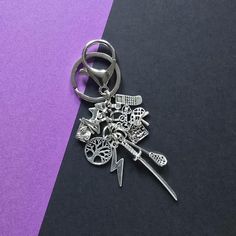 a metal keychain with various items attached to it on a purple and black background