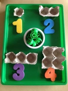 a green tray with numbers and shapes on it