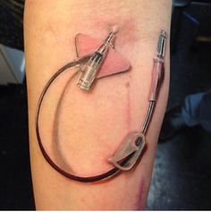 a tattoo that has some type of medical device on it's arm and is connected to an electrical cord