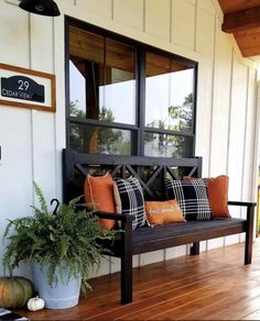 a wooden bench sitting on top of a hard wood floor next to a potted plant