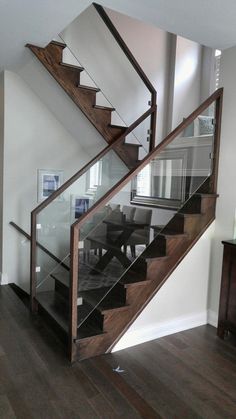 a wooden stair case with glass railing