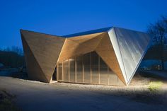 a building that has been made out of wood and is lit up by the night