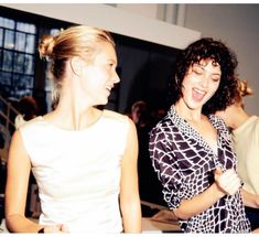 two women standing next to each other laughing