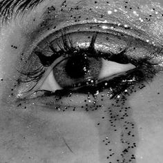 a woman's eye with glitter all over it