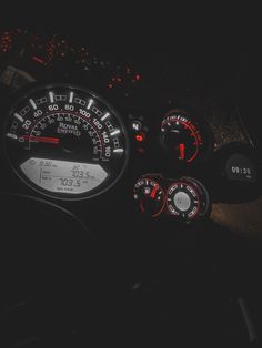 the gauges and dash lights of a car at night