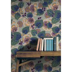 a book shelf with books on top of it next to a wallpapered background