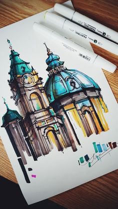 a drawing of a building with two towers and a clock on the top is next to a marker pen