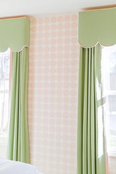 a bedroom with pink and green wallpaper and curtains