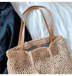 a straw bag sitting on top of a bed