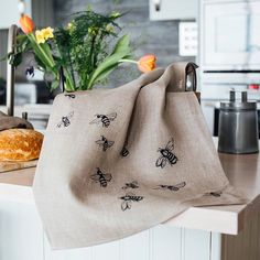 a kitchen counter with a bag on top of it and flowers in the vase next to it