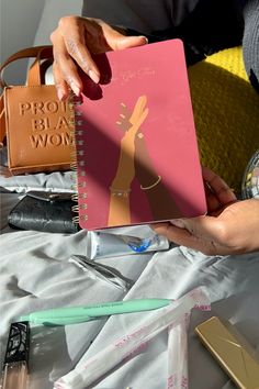 a person holding a pink notebook with the words probabably woman on it