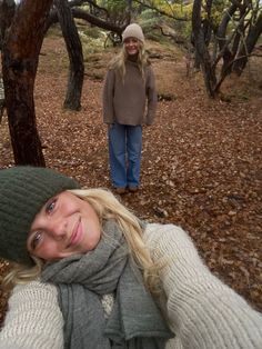 a woman is taking a selfie in the woods with her camera man behind her