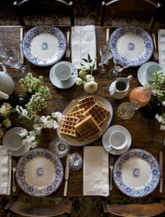 an overhead view of a table set with plates, cups and waffles on it