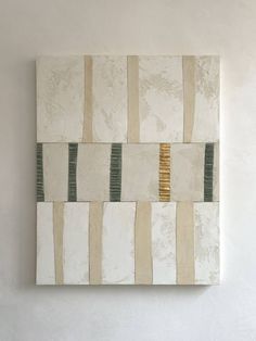 an abstract painting on a wall with white and green stripes in the center, against a neutral background