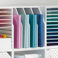 a white bookcase filled with lots of books and binders on top of it