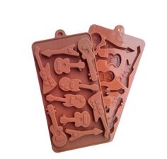 two chocolate molds with different types of tools on them, one is shaped like a guitar and the other has an assortment of keys