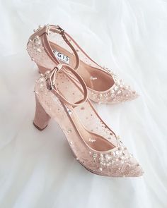 two pairs of pink shoes with pearls on them