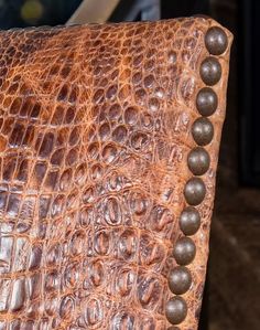 the back end of an alligator skin chair with metal studs on it's sides