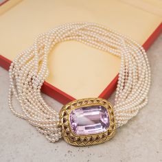 This elegant Mid-Century pearl necklace features a 89.92 carat kunzite and accent diamonds set in 18 karat yellow gold. The kunzite features a lightly saturated lilac hue and is set in a decorative vintage bezel. Twenty-two (22) triangle cut kunzite gems decorate the geometric engraved bezel for added scintillation. One hundred and twenty-six (126) near colorless diamonds are bead set in triangle mountings creating a sparkling accent to the soft purple kunzite. Finished with sixteen strings of p Exquisite Pearl Necklace For Formal Occasions, Exquisite Formal Pearl Necklace, Luxury Pearl Pendant Jewelry, Elegant Akoya Pearl Necklace With Gemstone, Formal Pearl Necklace With Gemstone, Luxury Evening Necklace With Pearl Pendant, Luxury Pearl Pendant Necklace For Evening, Luxury Akoya Pearl Necklace For Evening, Luxury Evening Pearl Pendant Necklace