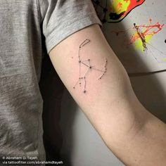 a man's arm with a zodiac sign tattoo on the left side of his arm