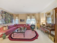 a living room filled with furniture and a large painting hanging on the wall above it