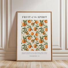 an orange fruit poster hangs on the wall in front of a wooden floor and white walls