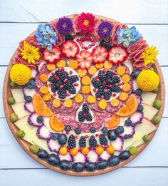 a wooden platter filled with fruit and flowers