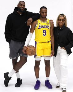 three people standing next to each other holding basketballs