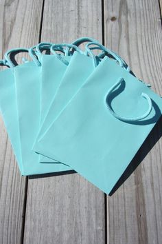 four blue bags sitting on top of a wooden table next to each other with handles