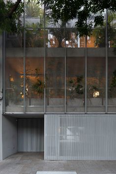 an empty parking lot in front of a building with plants growing out of the windows