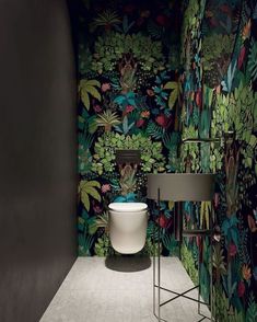 the bathroom is decorated with tropical wallpaper and green plants on the walls, along with a white pedestal sink