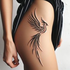 a woman's thigh with a bird tattoo on it