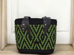 30cm width x 25cm height x 15cm depth. This beautiful Forest Green and Black Mosaic Tote Bag is hand crocheted with thick cotton thread. Its unique mosaic design stands out with the combination of forest green and black, providing a modern and elegant touch. The genuine leather handles provide strength and a sophisticated finish, while the cotton lining ensures durability. It is ideal for those looking for a functional yet unique bag, perfect for everyday or as a standout accessory for any occas Black Square Crochet Bag With Handles, Bohemian Black Crochet Bag For Everyday Use, Bohemian Black Crochet Bag For Daily Use, Black Bohemian Crochet Bag For Daily Use, Black Square Crochet Bag Bohemian Style, Black Bohemian Crochet Bag For Everyday, Black Bohemian Crochet Square Bag, Black Square Bohemian Crochet Bag, Bohemian Black Crochet Shoulder Bag