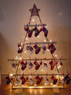 a christmas tree with stockings hanging from it's sides and lights on the bottom