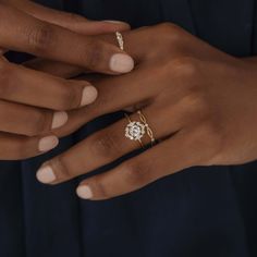 a woman's hand with two rings on her fingers, one is holding the other