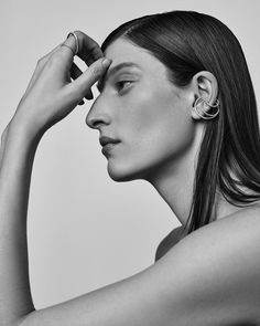 black and white photograph of a woman holding her ear