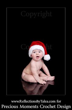 a baby wearing a santa hat sitting on top of a black surface with the words copyright below it