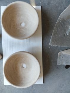 two white bowls sitting on top of a table