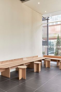 two wooden benches sitting next to each other in front of a window on the wall