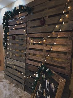 a wall made out of wooden pallets with christmas lights on the top and bottom