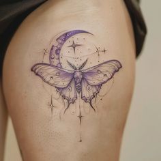 a woman's thigh with a butterfly and moon tattoo design on it, as well as stars