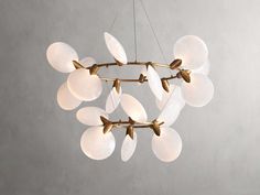 a chandelier with white and gold leaves hanging from it's center point