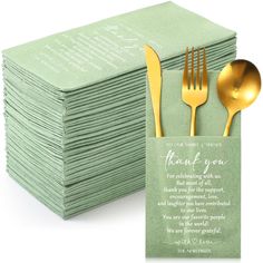 a stack of green napkins with gold forks and spoons on top of it