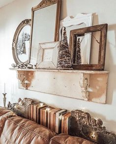 a living room filled with furniture and framed pictures on the wall over a leather couch