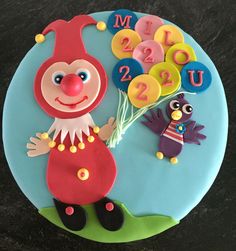 a birthday cake with a clown and numbers on it